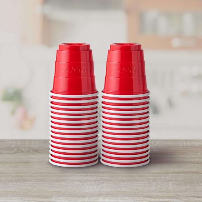 Two stacks of Hefty 2oz red party cups on a countertop