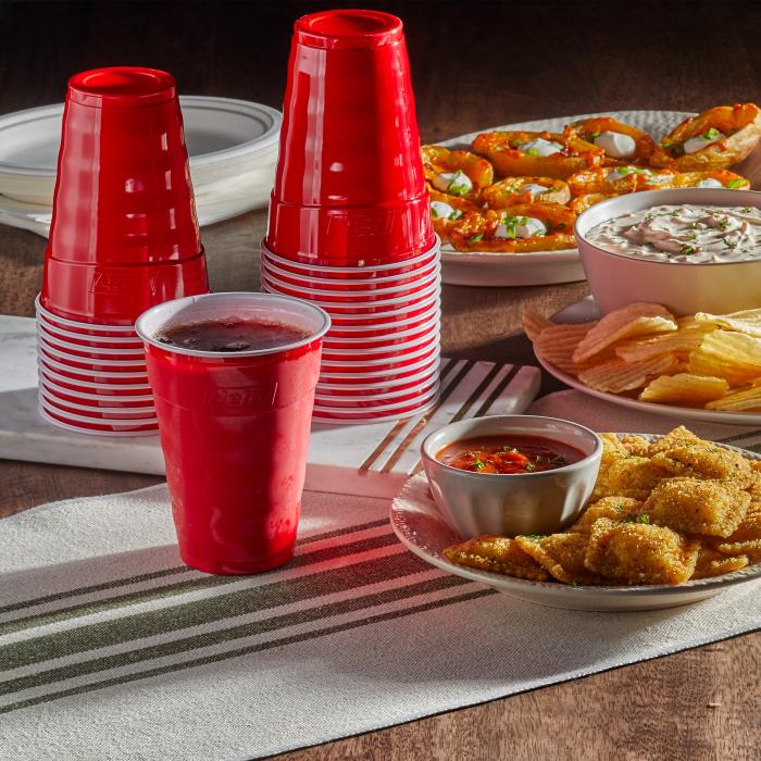 Hefty 18oz red party cups sitting on a table surrounded by appetizers