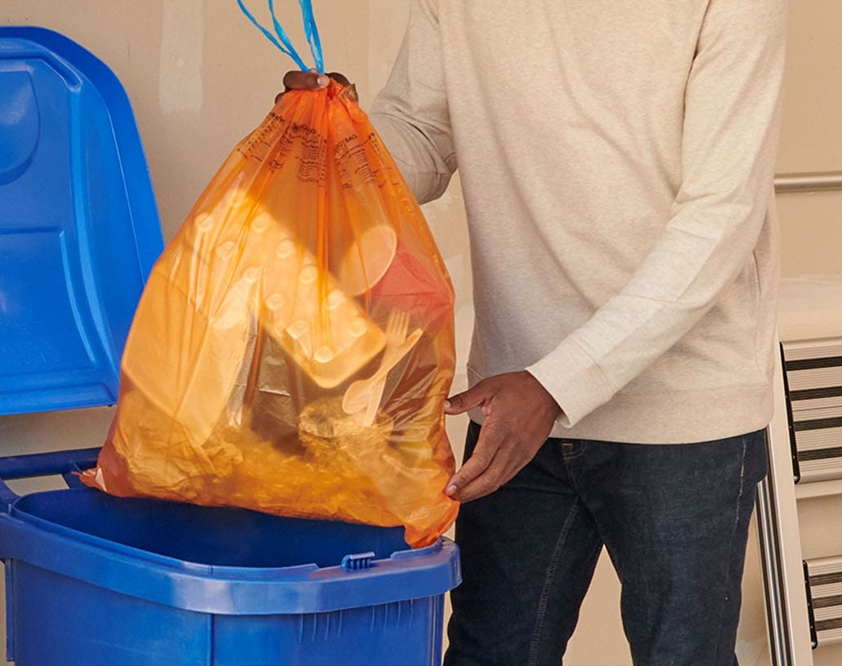 Man putting ReNew bag in trash can