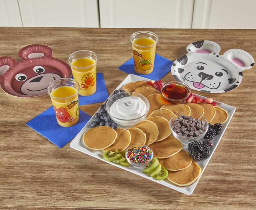 Hefty Zoo Pals Cups and Plates sitting on a table alongside a platter of pancakes