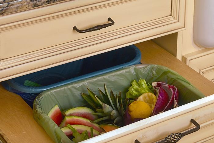 Food waste in a compostable bag in a kitchen trash container.
