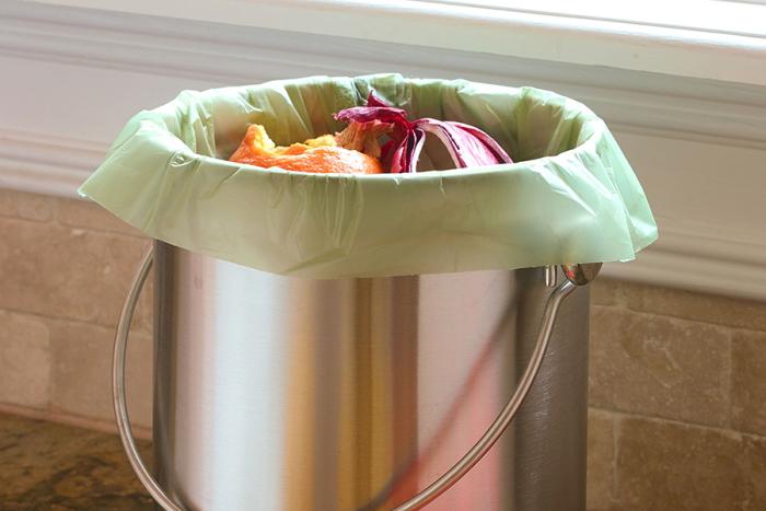 Small compostable bag in a kitchen compost container.