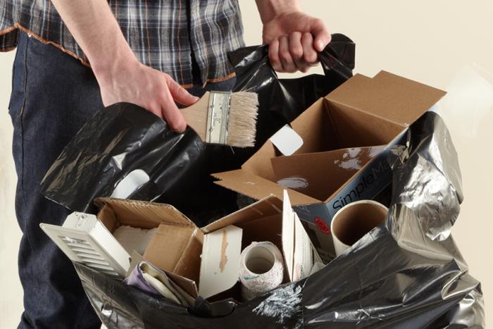 Person filling a load and carry contractor bag with painting and construction supplies.