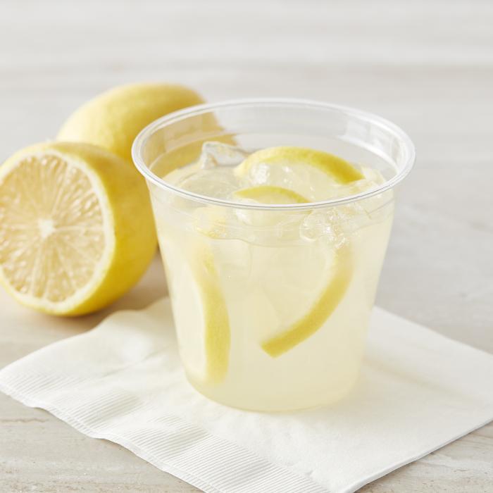 Lemonade in a 9oz clear cup sitting on a white paper napkin
