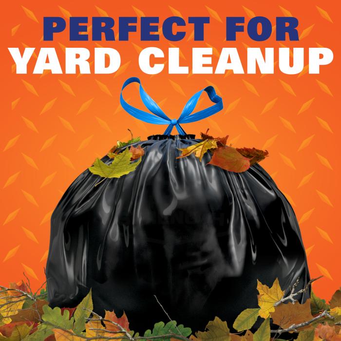 stuffed black trash bag sitting in a pile of leaves